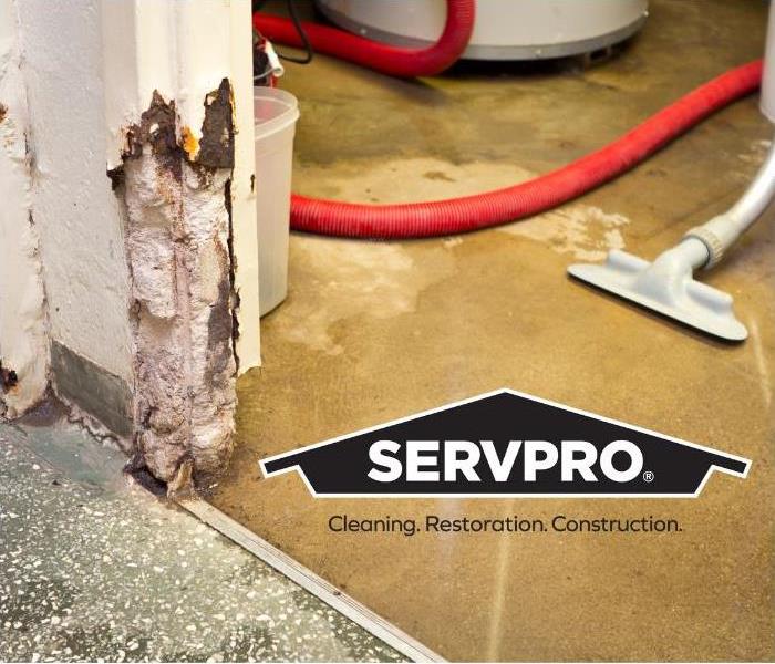 flooded water being extracted with Servpro logo 